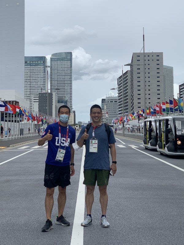 東京オリンピック選手村のメインストリートに立つ仲野広倫(左)と弟の仲野有草(右)